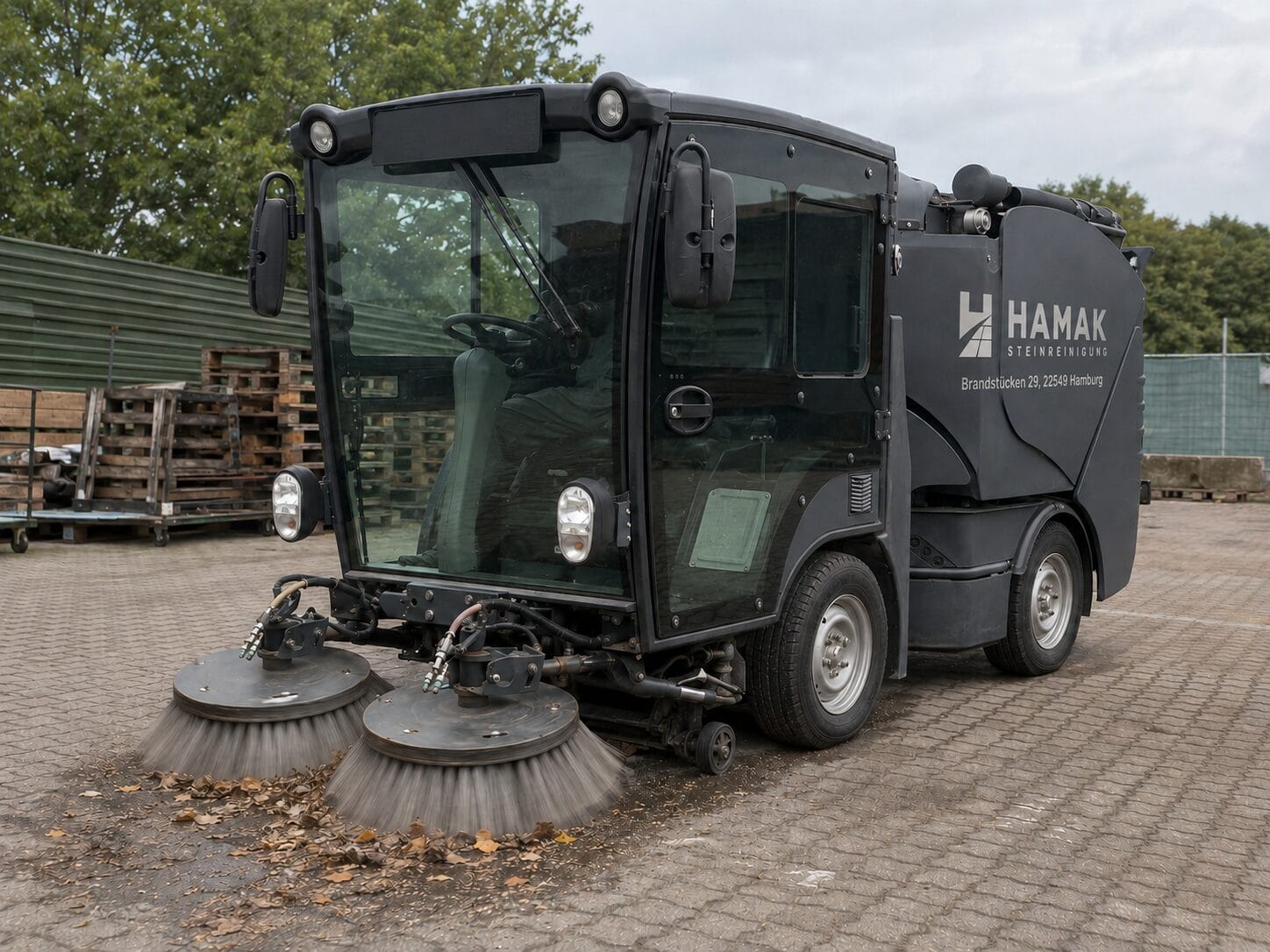 Kompakte kommunale HAMAK Kehrmaschine nimmt mit zwei Frontkehrbesen Laub und Sand auf