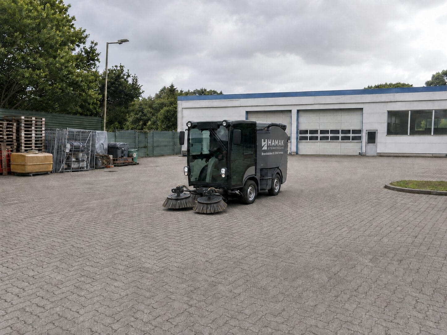 HAMAK Kehrmaschine bei einem regelmäßigen Kehrdienst auf einem Betriebshof